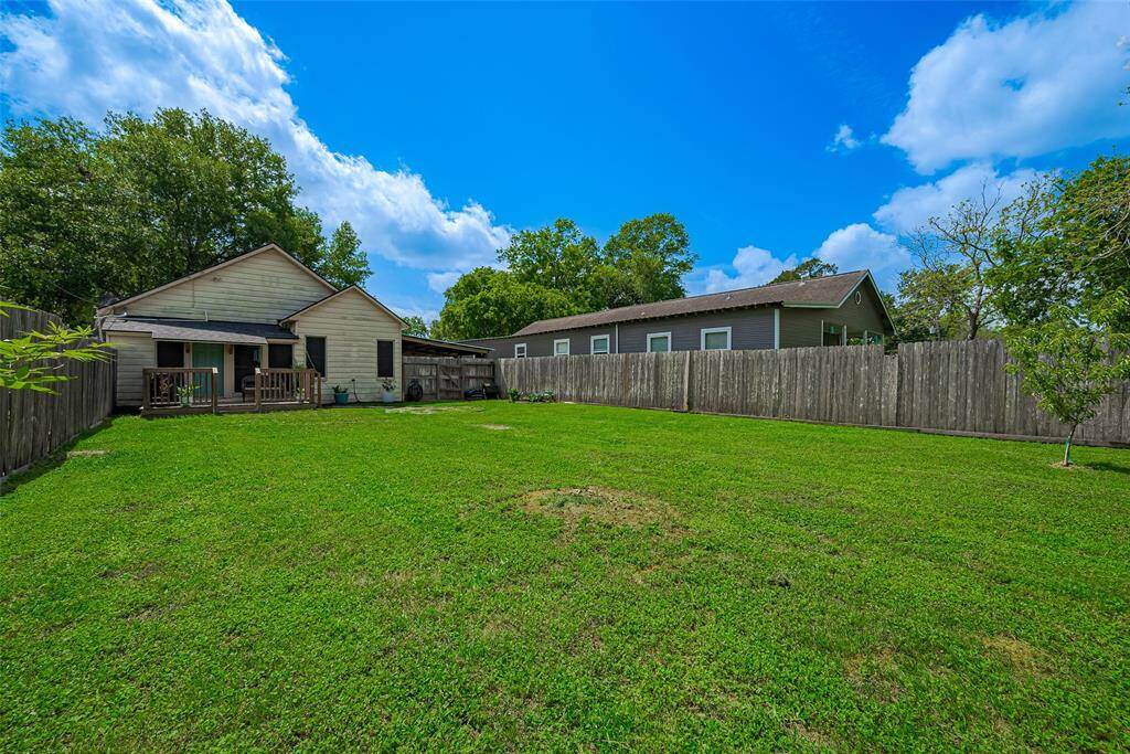 The spacious backyard features a charming wooden deck, ideal for outdoor dining, relaxation, or entertaining, with plenty of room to enjoy the outdoors in comfort.