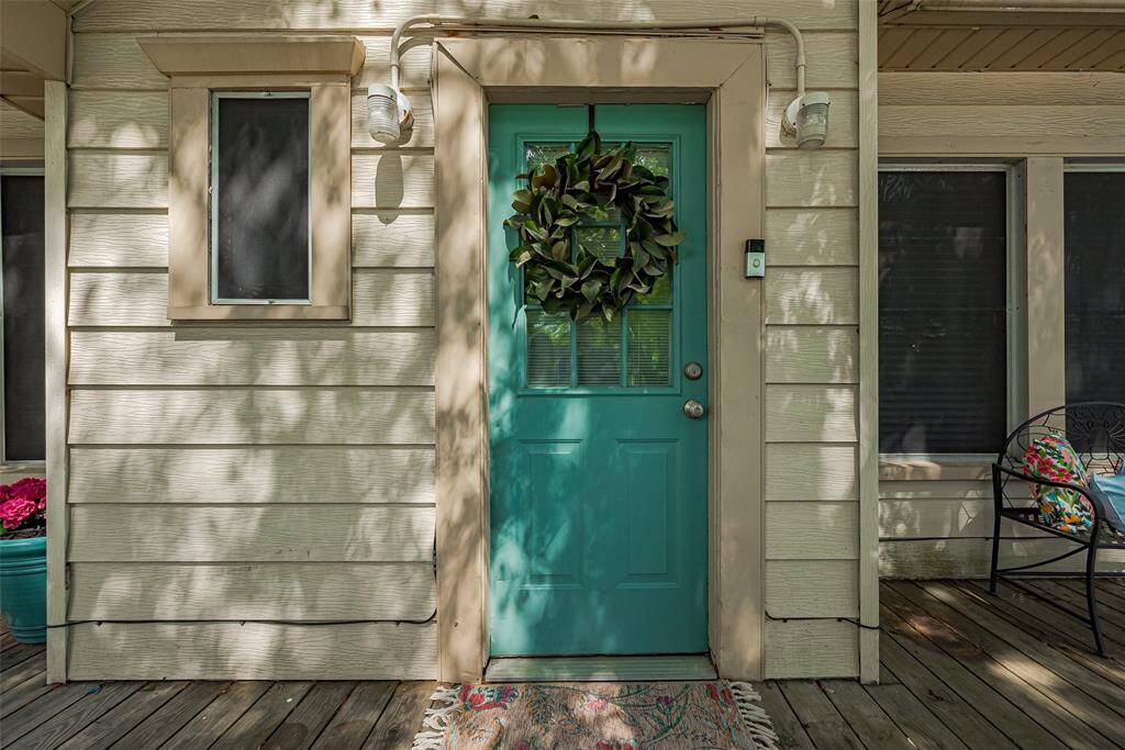 Charming front entrance with a vibrant front door. The space includes a cozy porch area, perfect for relaxation.