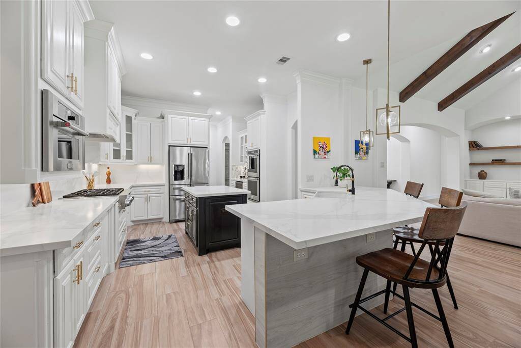Quartz countertops paired with a coordinating stone backsplash not only provide a durable and elegant surface for food preparation but also add a touch of luxury and sophistication to the kitchen.