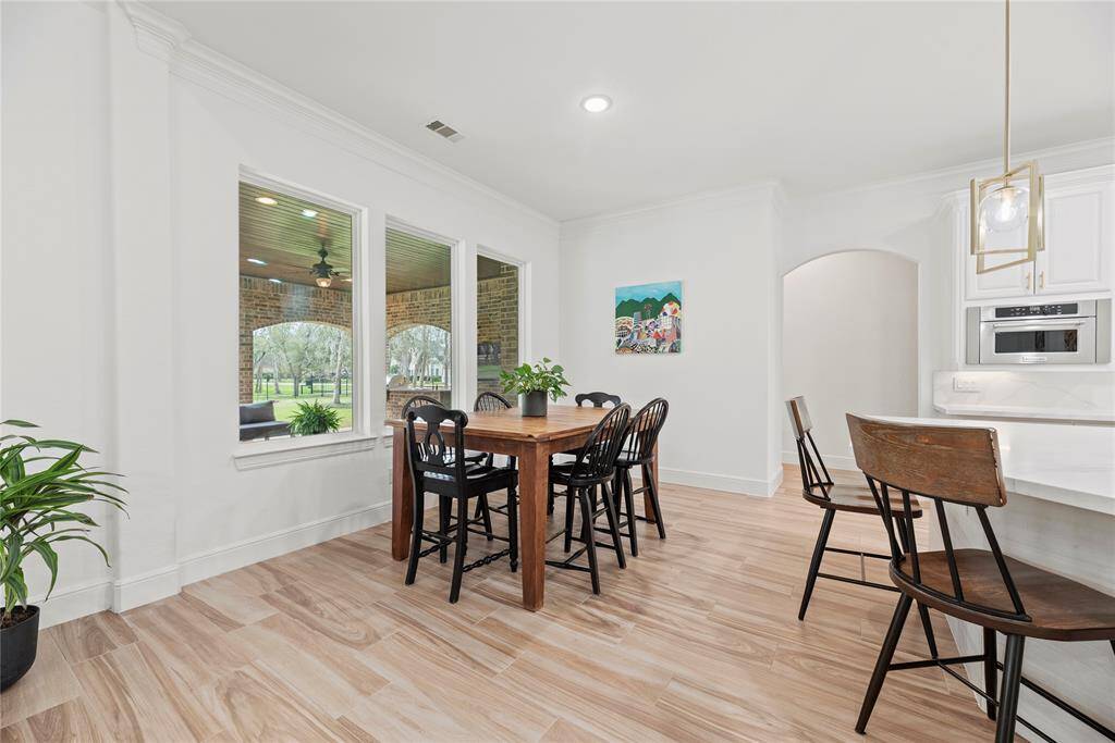 The breakfast room is ideal for a full-sized table and features easy care floors and large bright windows overlooking the picturesque back yard.
