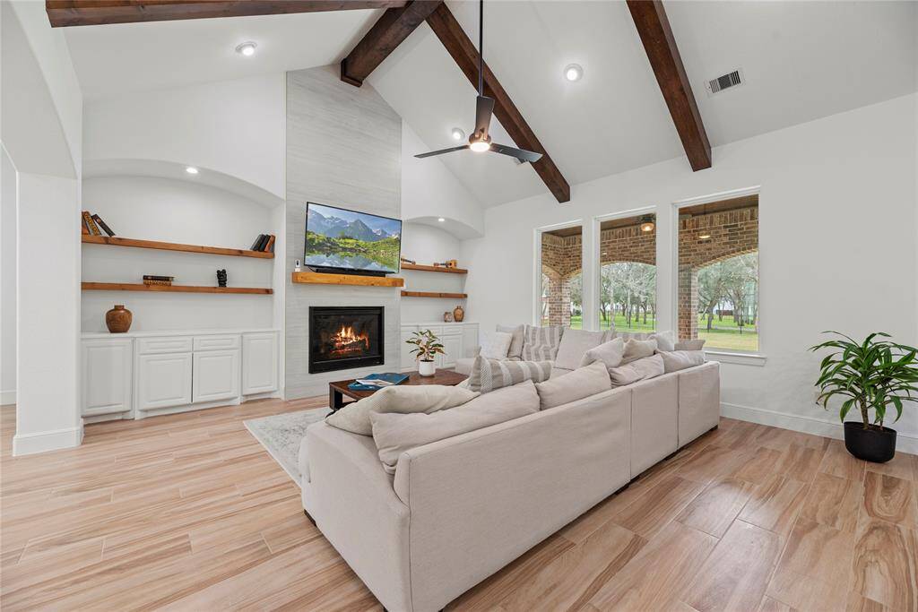 The custom built cabinetry along with the inviting fireplace become a focal point that anchors the room and invites people to gather and linger, making it a cherished feature of the living area.
