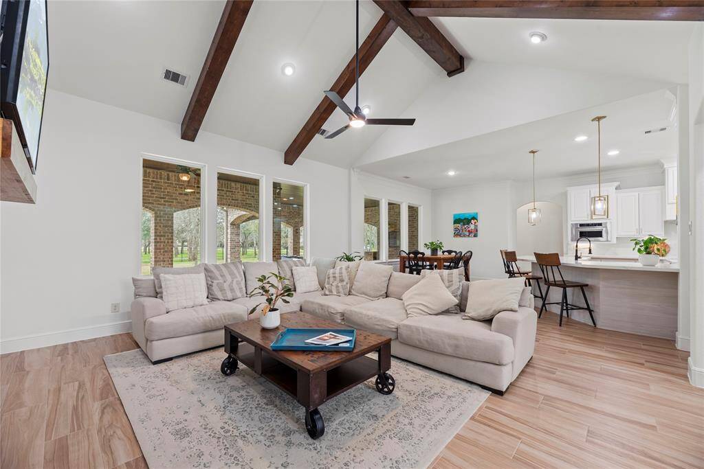 A chic living room space flooded with natural light is delightful! The wall of windows not only brings in abundant sunlight but also offers expansive views of the surrounding landscape, connecting the indoors with the outdoors in a seamless way.