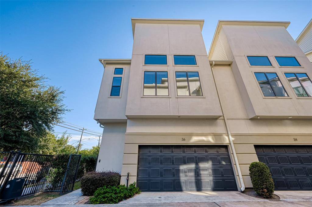 Welcome to 36 N Hutcheson – a striking modern residence located in the heart of Houston’s vibrant East End. This front exterior shot showcases the clean architectural lines, attached garage, and gated entrance to the private side yard – offering both convenience and security. The sleek curb appeal sets the tone for the stylish interiors waiting inside.