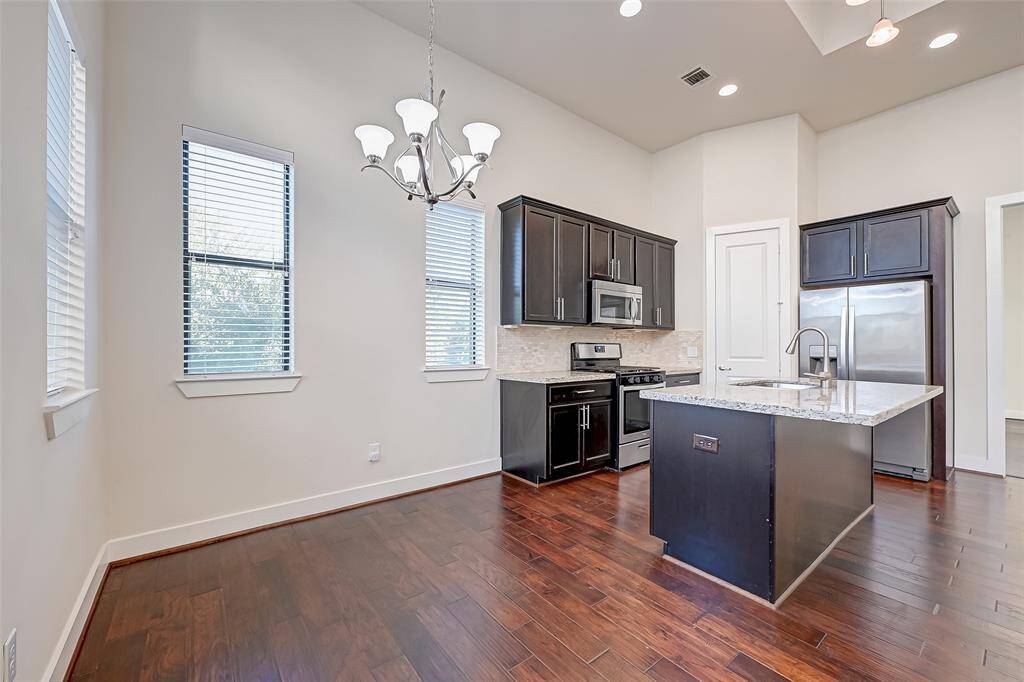 From the dining area, the kitchen shines with granite countertops, modern cabinetry, and stainless steel appliances. The open design offers both functionality and style, with ample workspace and storage for everyday cooking and entertaining.