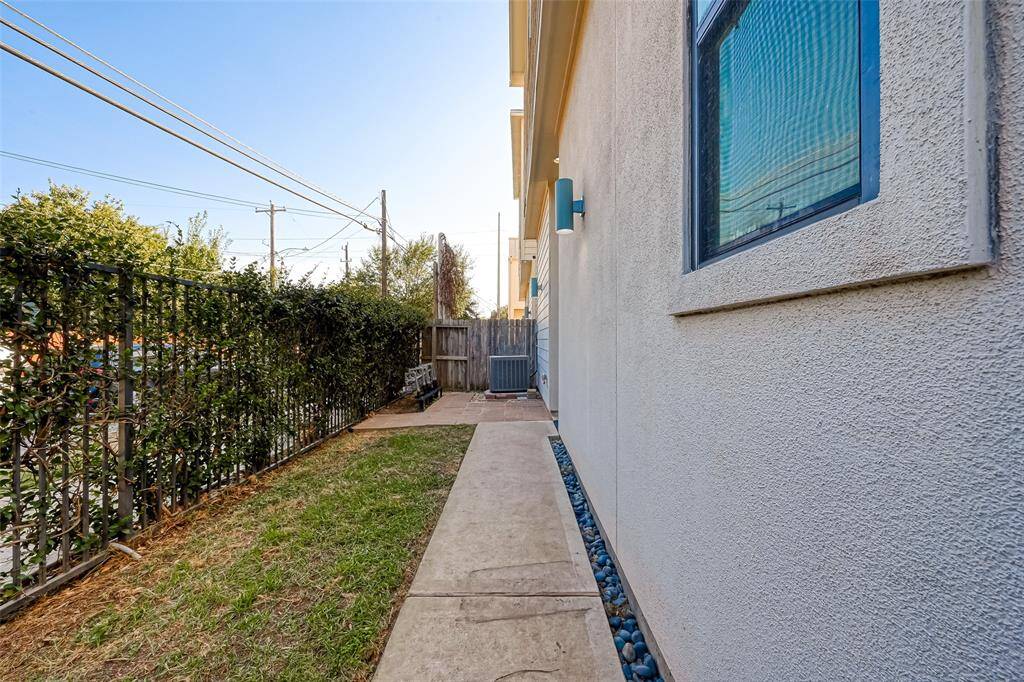 This view of the gated side yard and entrance highlights a private outdoor space, ideal for grilling, entertaining, or simply relaxing. The secure gate ensures privacy, making it a perfect spot to enjoy the outdoors in a peaceful setting.