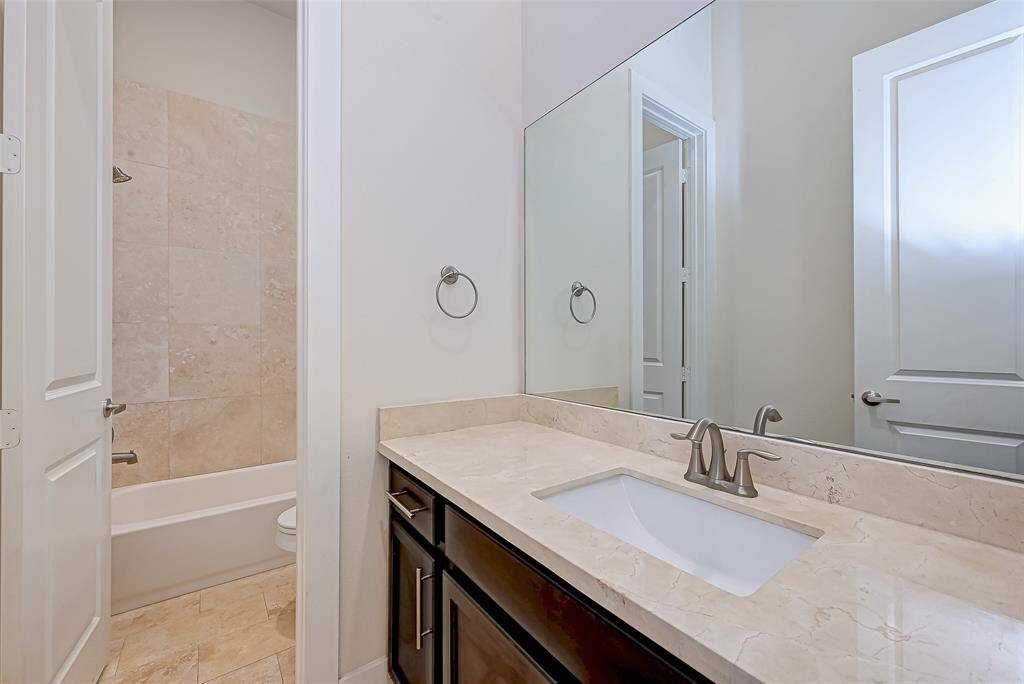 The secondary bathroom on the first floor offers sleek finishes, a modern vanity, and a tub/shower combo. Conveniently located between both bedrooms, it provides comfort and functionality for guests or roommates.