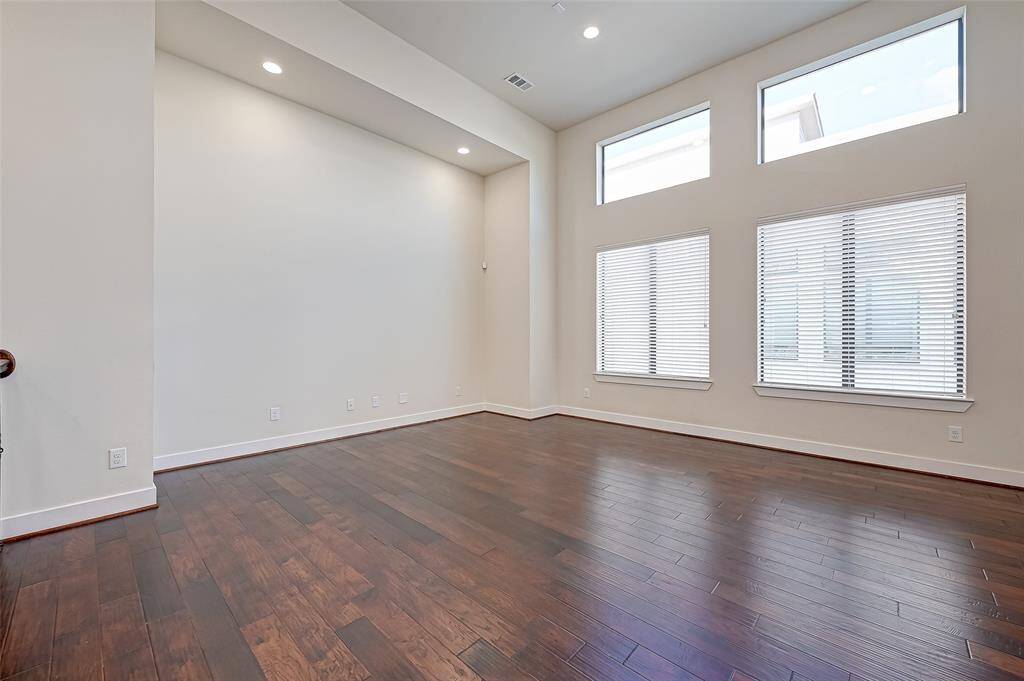 This view of the second-floor living area highlights the expansive windows that flood the space with natural light. The abundance of sunlight enhances the open feel and showcases the clean, modern design throughout.
