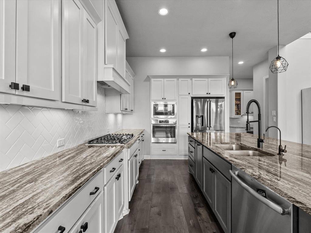 Chef's eat-in island kitchen features 42" cabinets with crown molding, under cabinet lighting, designer backsplash, stainless steel appliances and legthy countertops