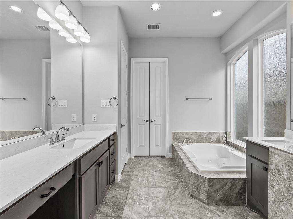 The primary en-suite bath features dual vanities, a soaking tub, walk-in shower and a large walk-in closet
