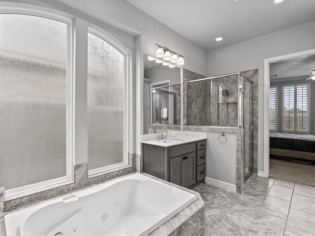 The primary en-suite bath features dual vanities, a soaking tub, walk-in shower and a large walk-in closet