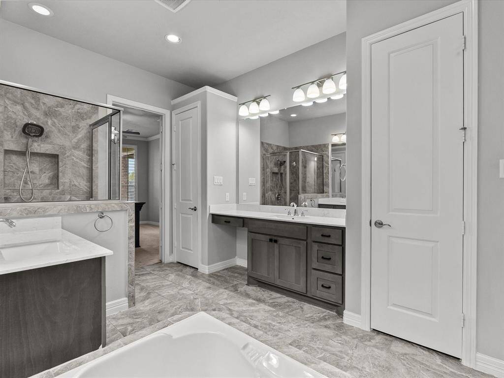 The primary en-suite bath features dual vanities, a soaking tub, walk-in shower and a large walk-in closet