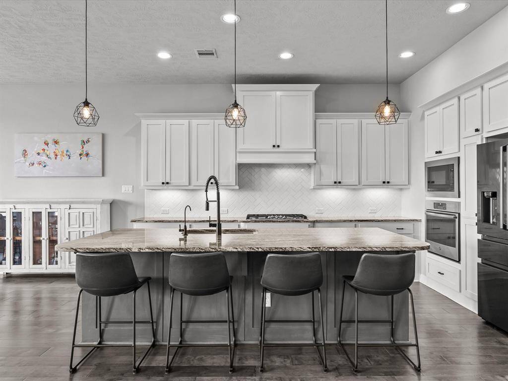 Chef's eat-in island kitchen features 42" cabinets with crown molding, under cabinet lighting, designer backsplash, stainless steel appliances and legthy countertops