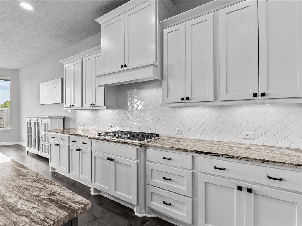 Chef's eat-in island kitchen features 42" cabinets with crown molding, under cabinet lighting, designer backsplash, stainless steel appliances and legthy countertops