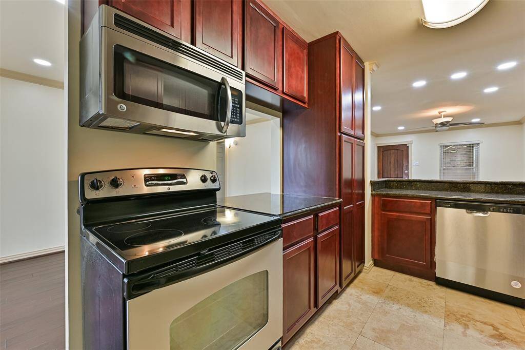 Featuring sleek stainless steel appliances and gleaming granite countertops, this kitchen is both functional and stylish.