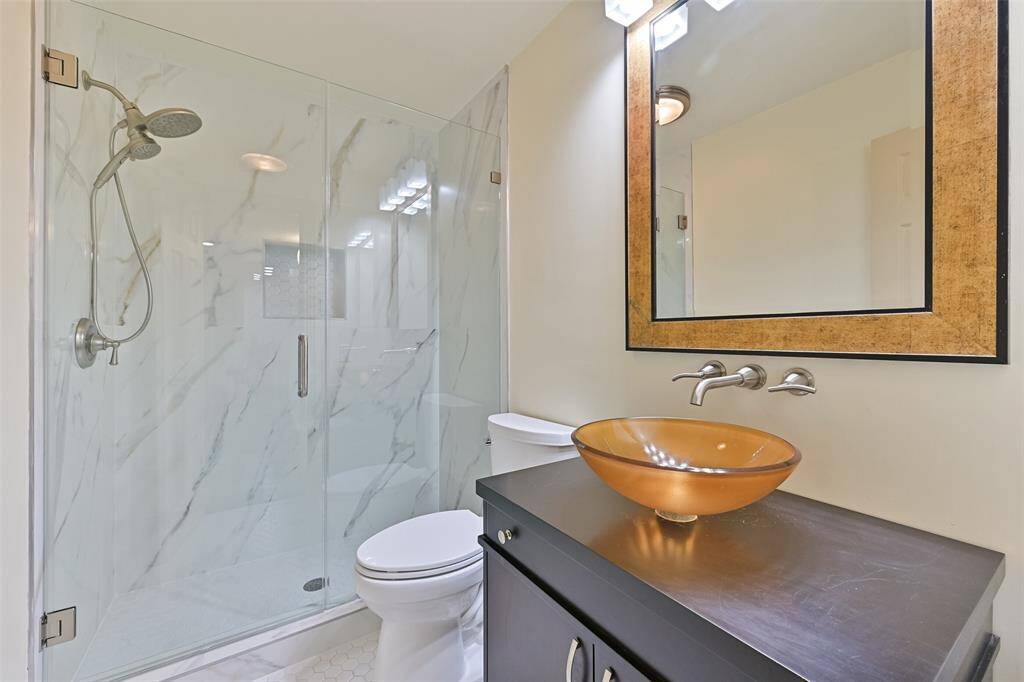 Enjoy the spa-like updated bathroom which features a sleek standing shower with a glass door for a modern touch. A vessel sink adds a stylish flair to this well-appointed bathroom.