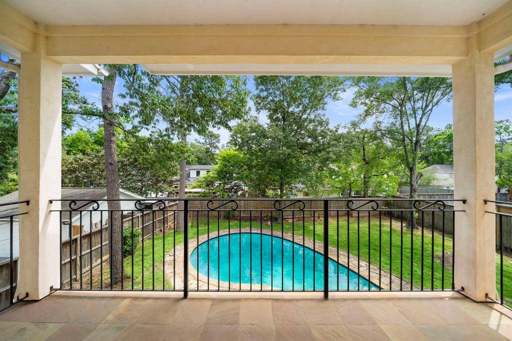 Upstairs balcony overlooks backyard and pool.