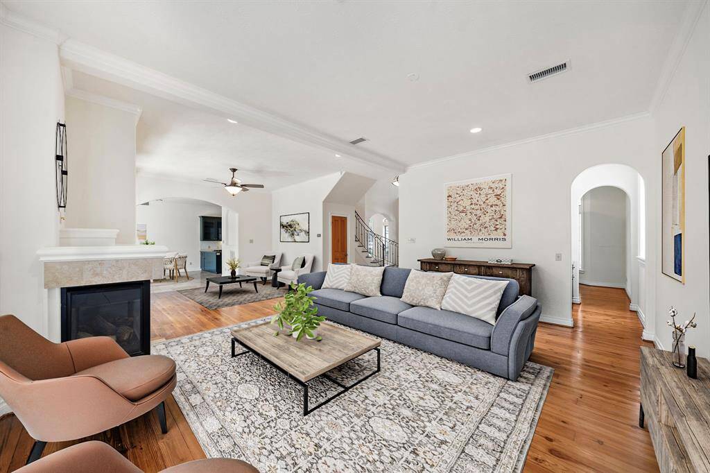 Inviting living area with pine floors and gas log fireplace.  Hallway has wet bar leading through to study. Virtually Staged.