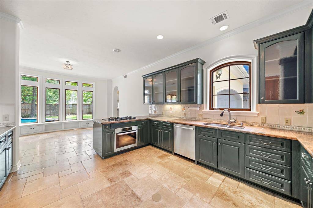 Light and bright Kitchen with travertine tile, stainless appliances, and walk in pantry.