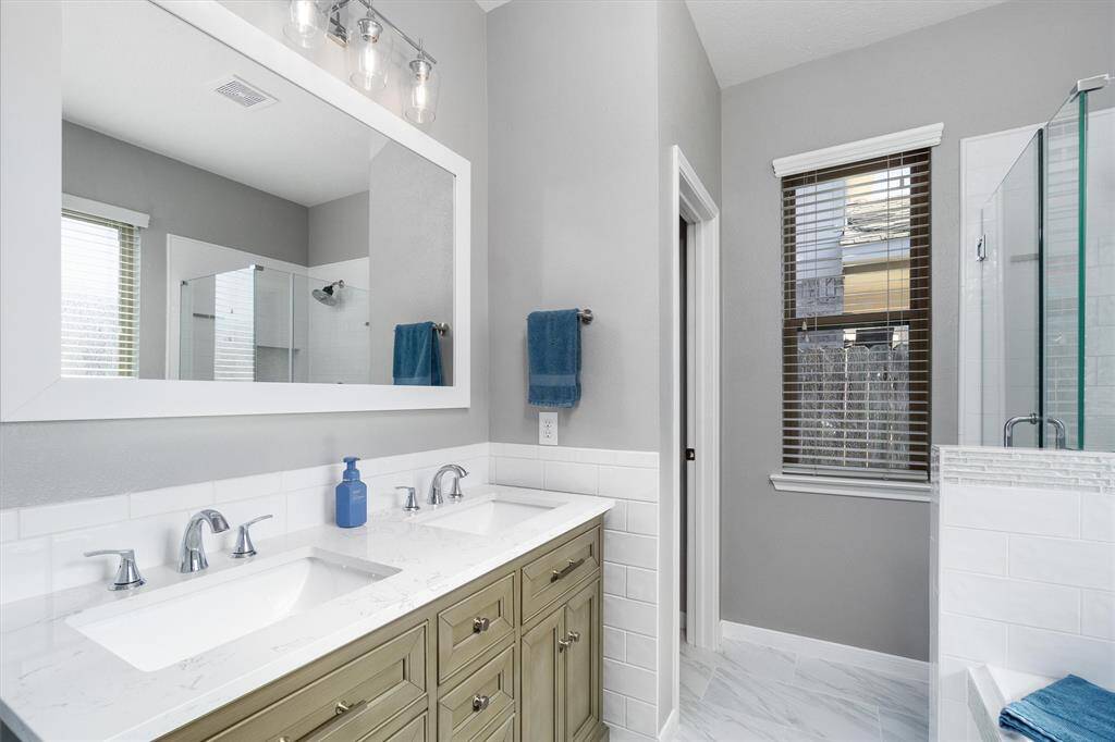 Beautifully updated primary en suite. Double sinks, large framed mirror.