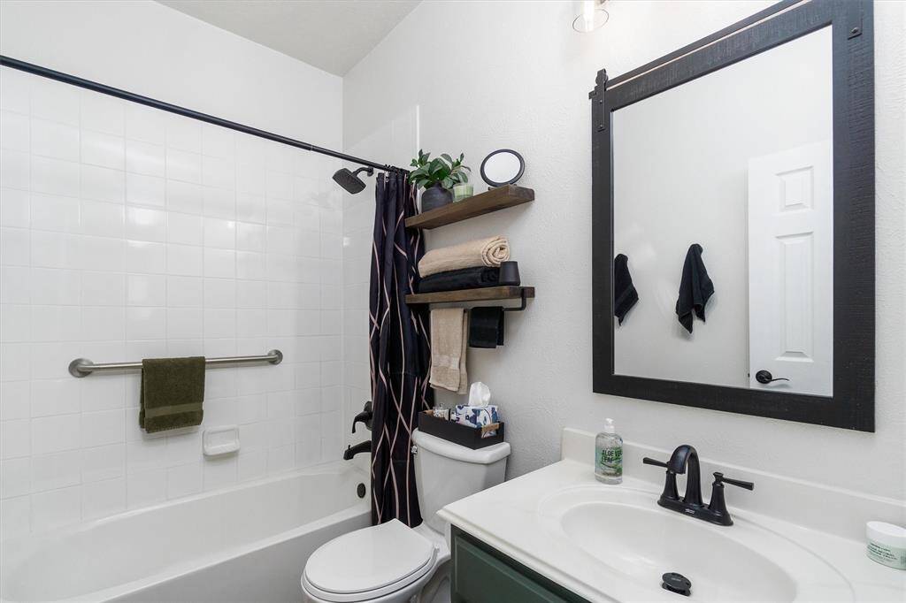 Second full bath with framed mirror, fully tiled tub/shower combo, new toilet and fixtures