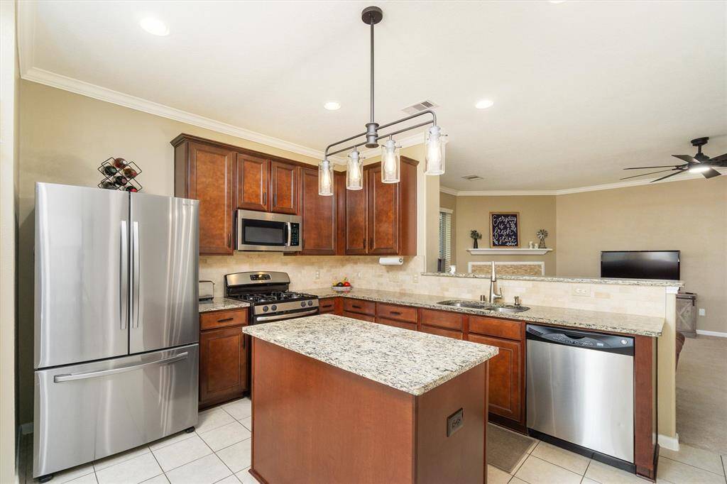 Kitchen area featuring granite countertops, stainless steel appliances and as island for added counter/storage space