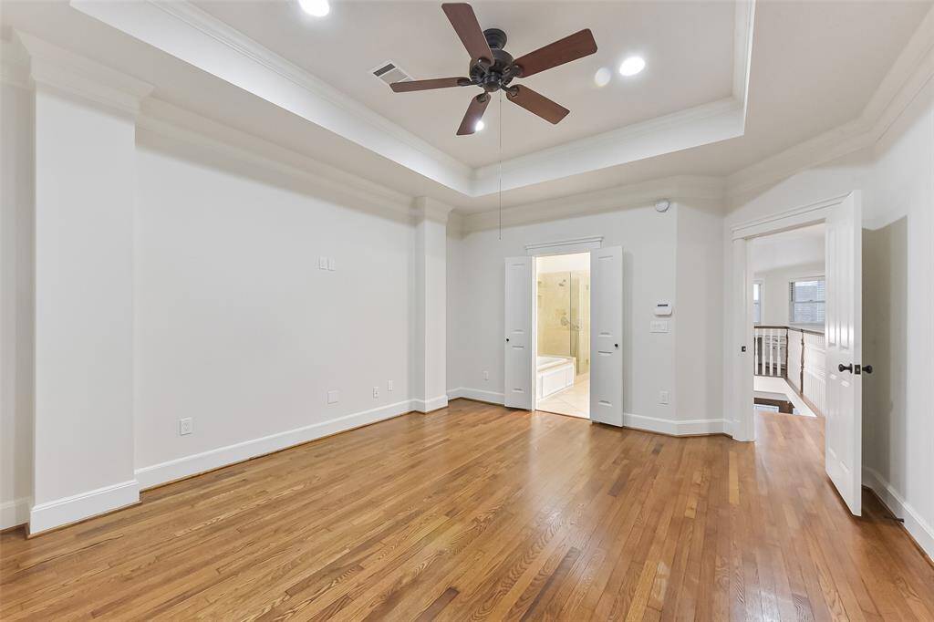 Another view of the Primary suite with double doors leading to the primary bathroom.