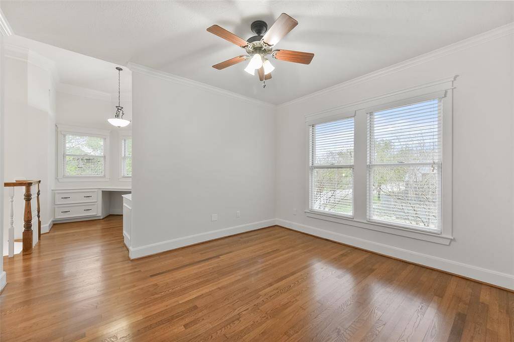 Light-filled upstairs game room with wood floors and large windows facing the front of the house.