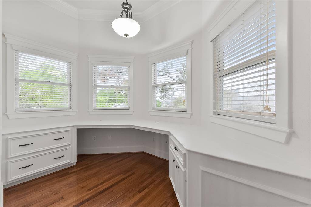 This bright study area in the upstairs landing features built-in cabinetry with ample storage and counter space, complemented by large windows that provide plenty of natural light. It's perfect for a home office or study area.
