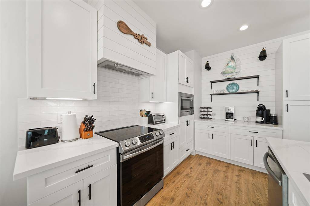 The kitchen features white cabinets,creating a clean and timelessaesthetic.