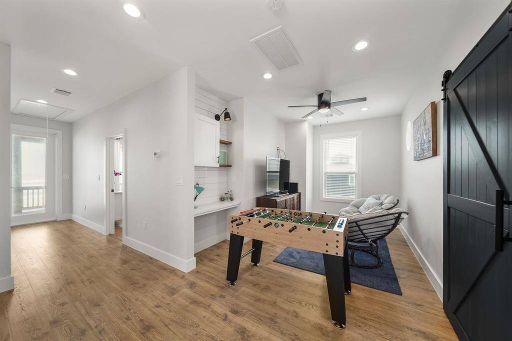 The game room features a ceiling fan, recessed lighting, and large window.