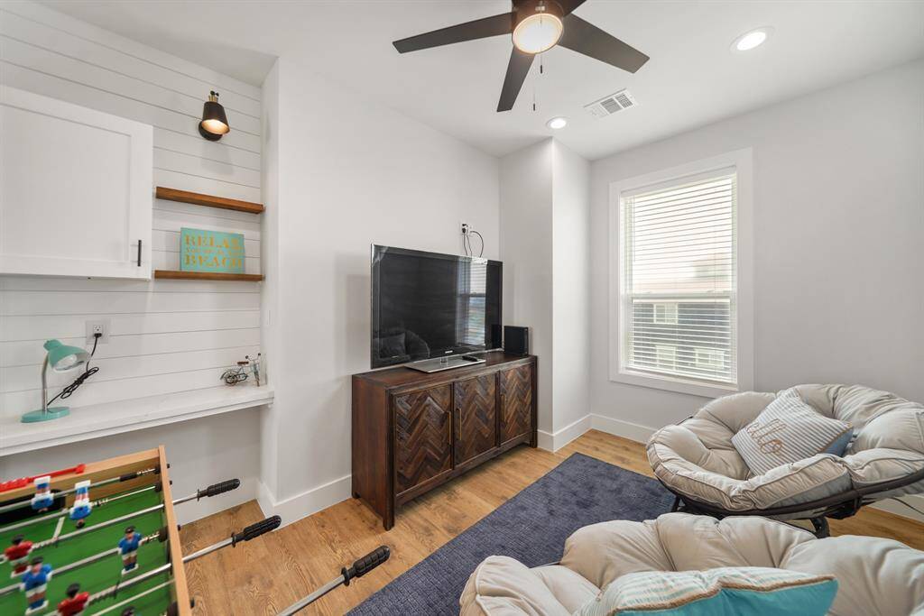 The game room features a ceiling fan, recessed lighting, and large window.