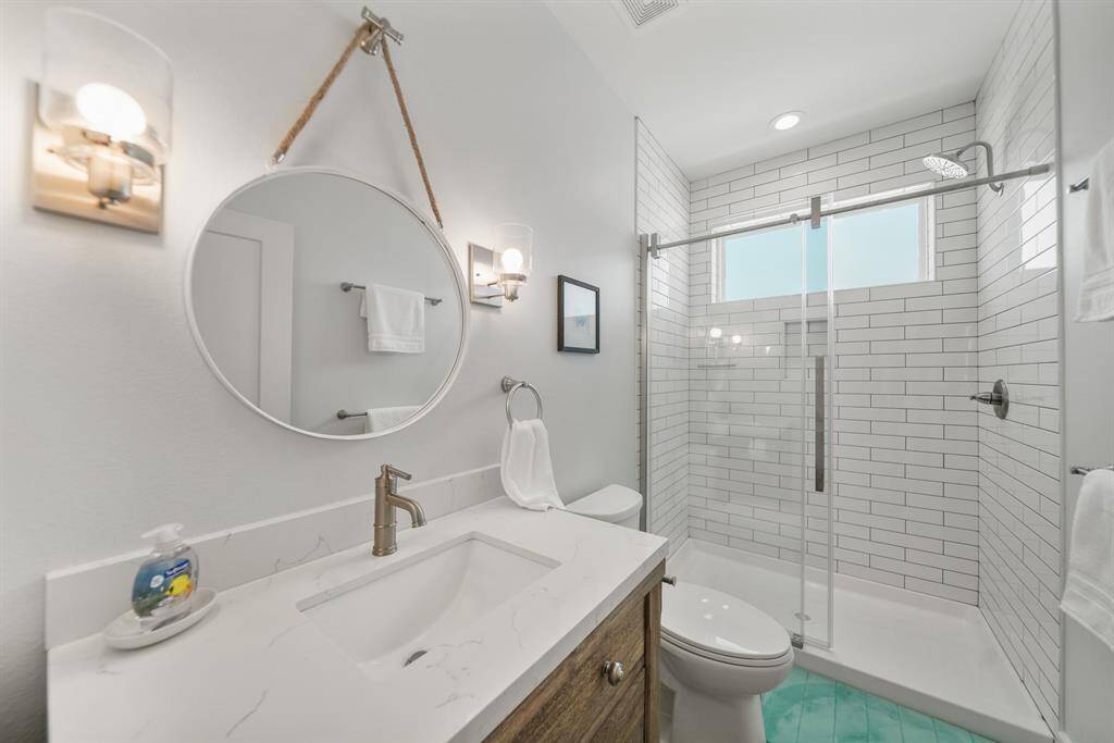 Secondary bathroom features a walk-in shower with tile surround.