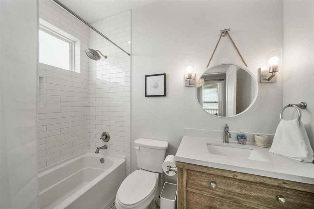 Third bathroom features a tub and shower combo with tile surround.