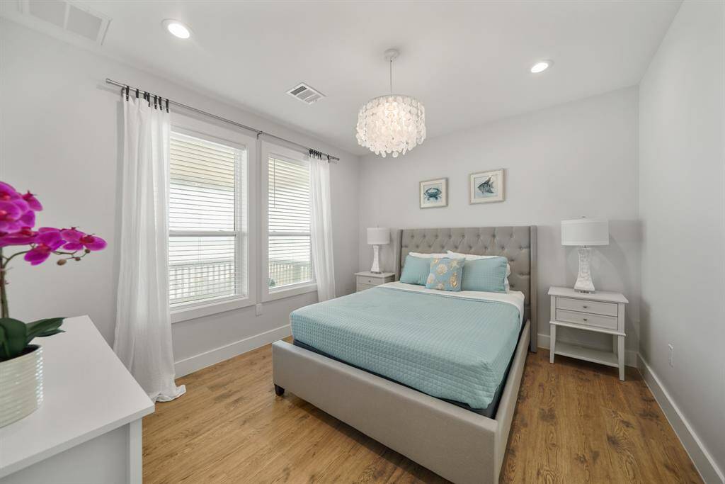 Fourth bedroom features awindow, chandelier, and recessed lighting.