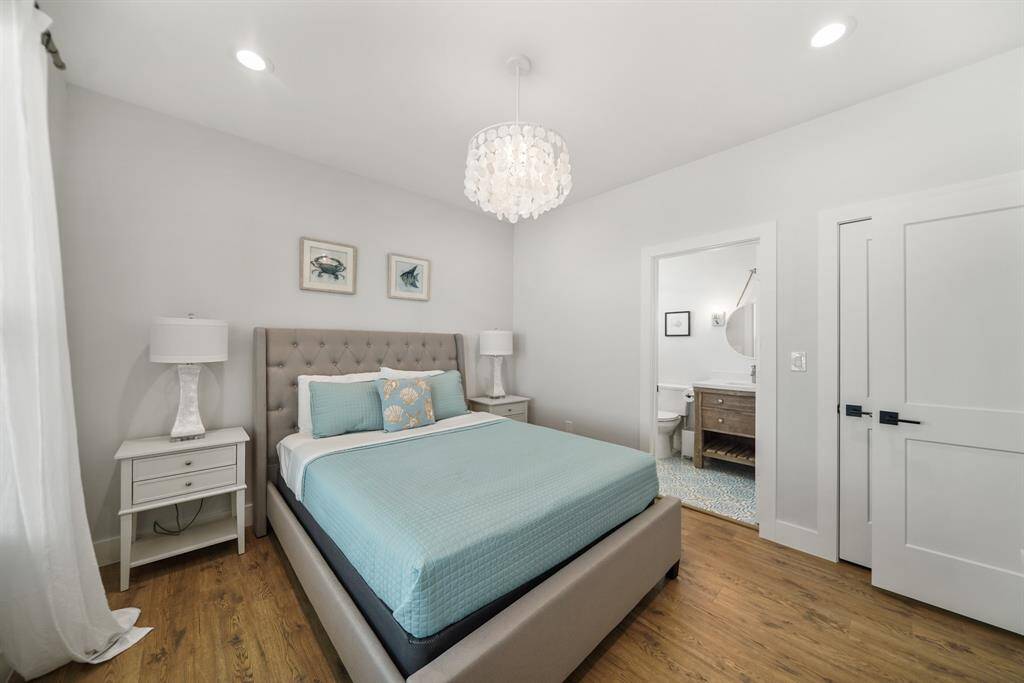 Fourth bedroom features awindow, chandelier, and recessed lighting.