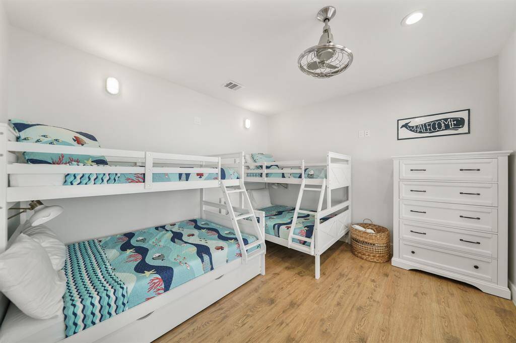 Fifth bedroom features awindow, ceiling fan, and recessed lighting.