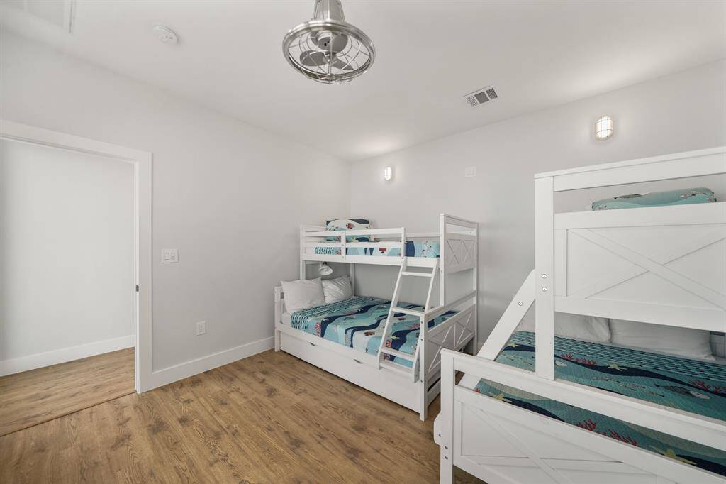 Fifth bedroom features awindow, ceiling fan, and recessed lighting.