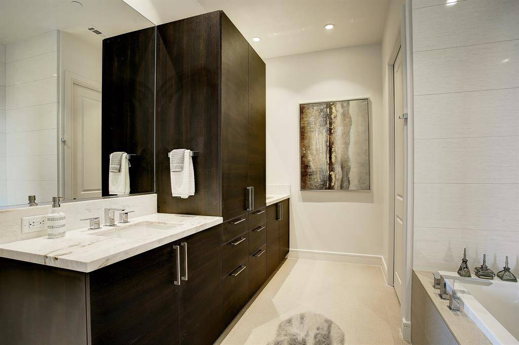 The master bathroom has double sinks and lot of Cabinets.