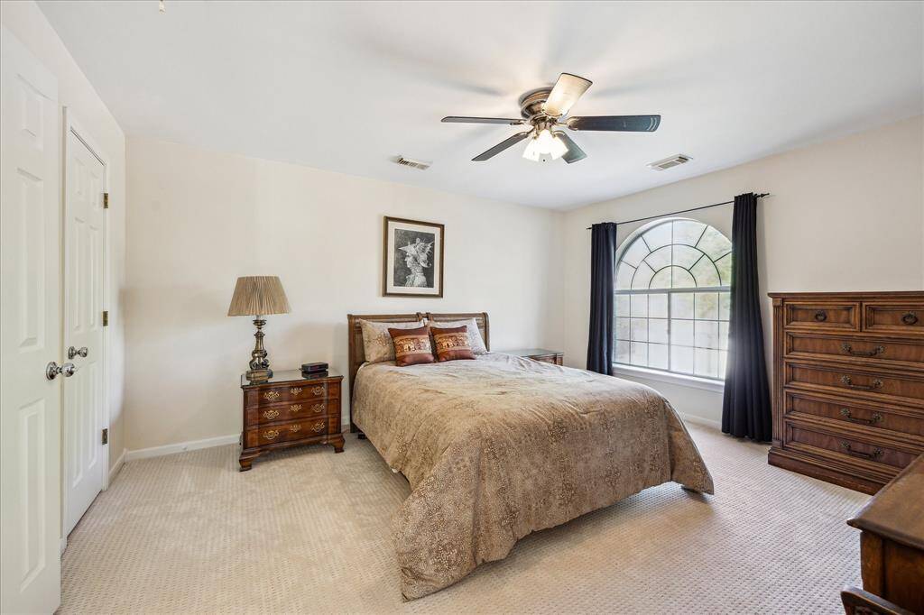 This outdoor space includes a pool and spa surrounded by a paved patio, offering plenty of room for lounging and entertaining in a private, fenced setting.