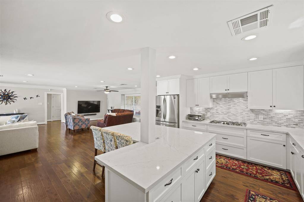 The Kitchen boasts Quartz Counters (White with Grey Vein), Polished Marble Subway Tile Backsplash, White Painted Shaker Style Cabinets and Soft Close Drawers, Deep Drawers for Storage of Cookware and Small Kitchen Appliances, LED Recessed Lighting.Trash Pull Out Cabinet (2 Bins), and Crown Molding.