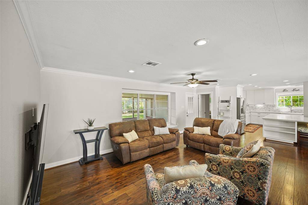 The Family Room offers Walnut Hued Handscraped Hardwood Floors, Crown Molding, and LED Recessed Lighting.