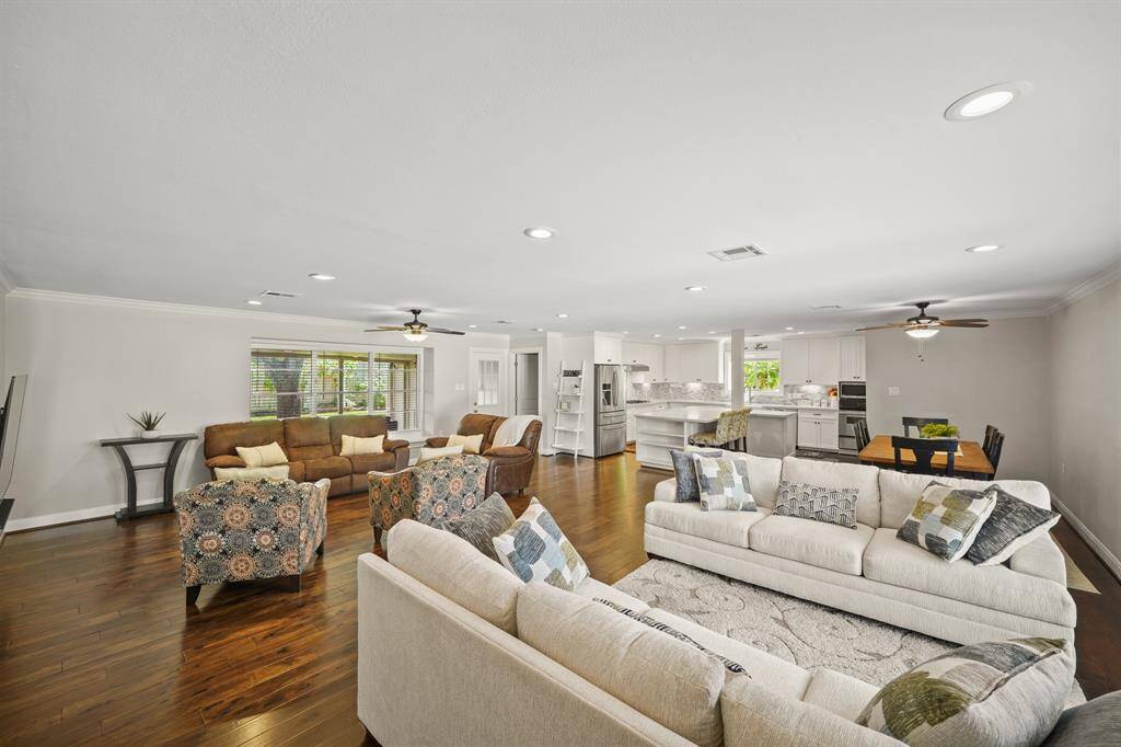 The Open Concept in the Living Area/Den features Walnut Hued Handscraped Hardwood Floors and Light Grey Designer Paint with White Trim.
