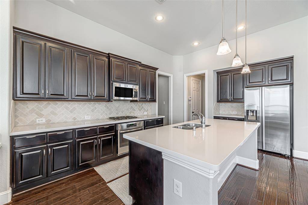 Large kitchen island with plenty of countertop spaces and stainless steel appliances.