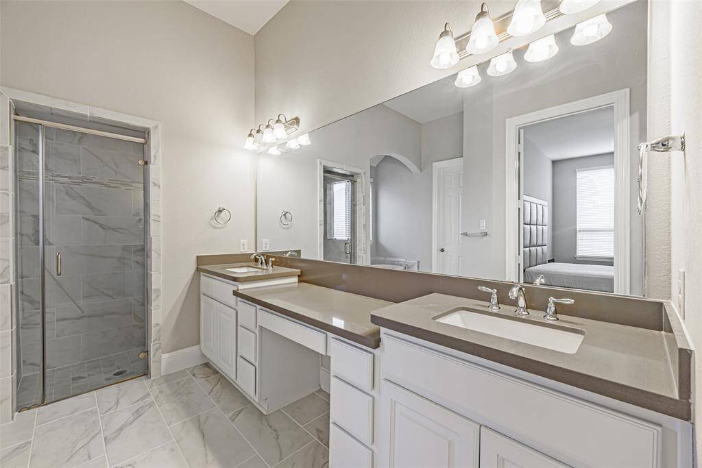 Primary bathroom with double sinks and vanity area.
