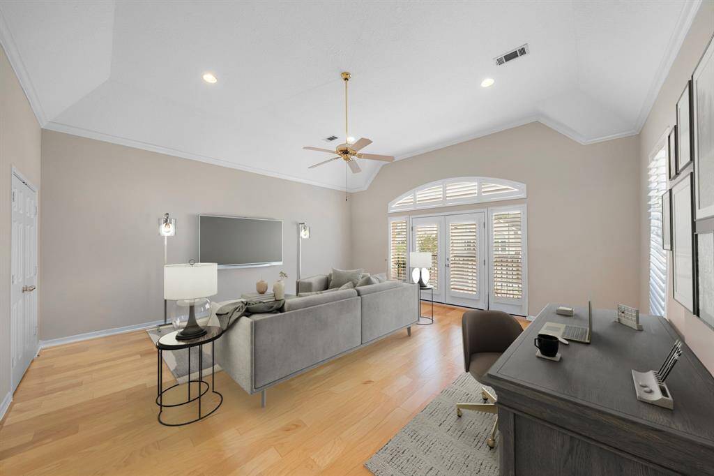 Spanning nearly the size of a primary suite, this oversized secondary bedroom features soaring ceilings, wood floors, and enough space for lounging, working, or hosting guests. This photo has been virtually staged.