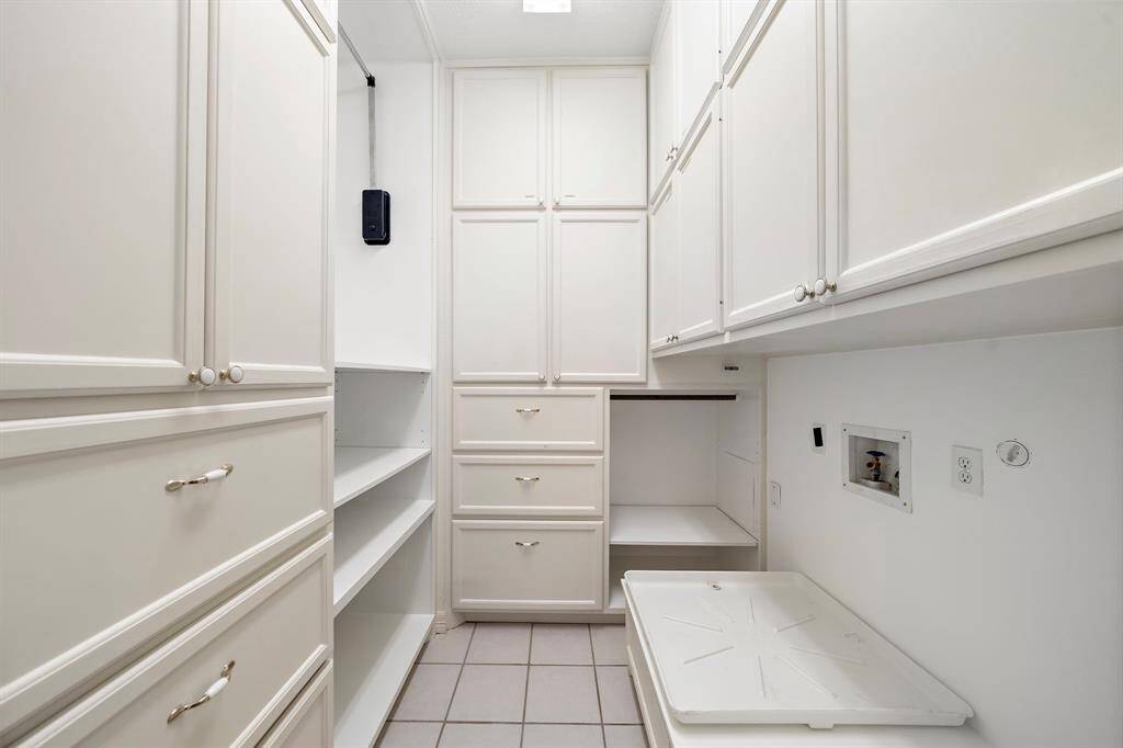 An abundance of built-in cabinetry, shelves, and counter space makes this upstairs utility room as functional as it is organized.