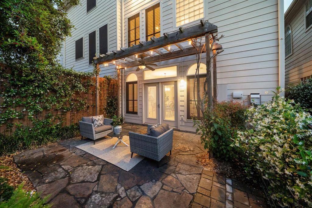 Twilight ambiance sets the mood in this enchanting courtyard space, where a fan-equipped pergola adds year-round comfort and style.