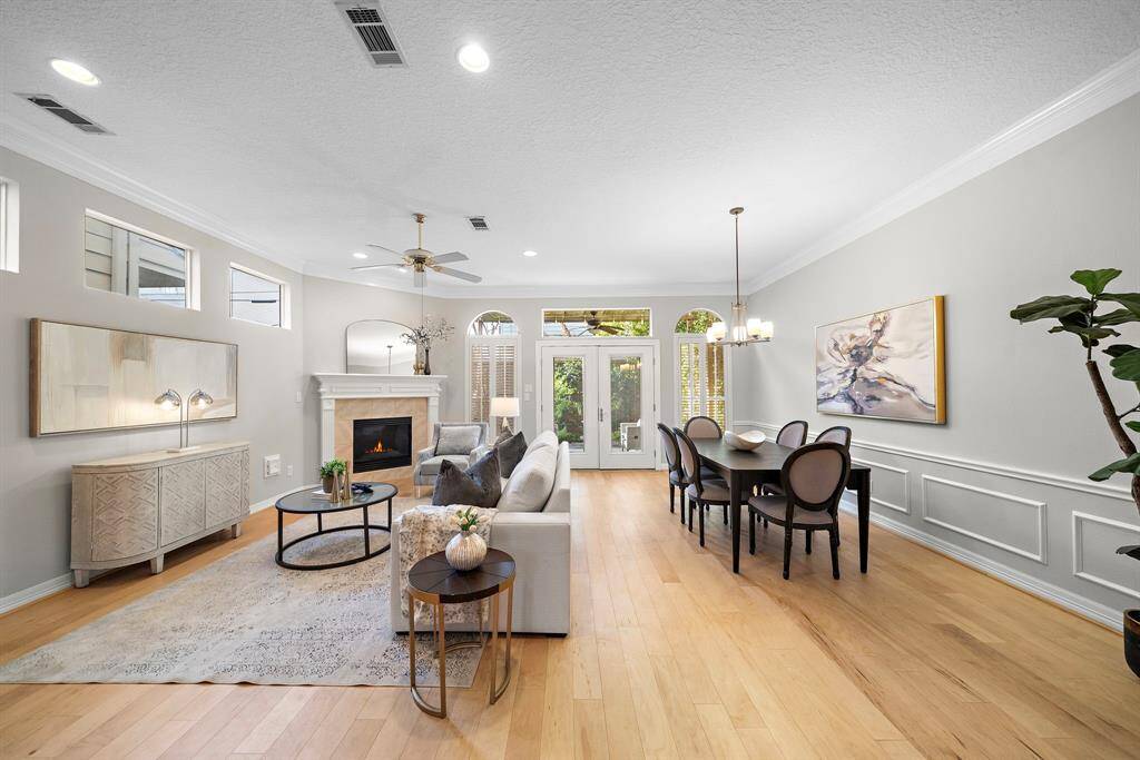 Flooded with natural light, this spacious open-concept living and dining area blends elegance and ease with a cozy fireplace and access to the private patio.