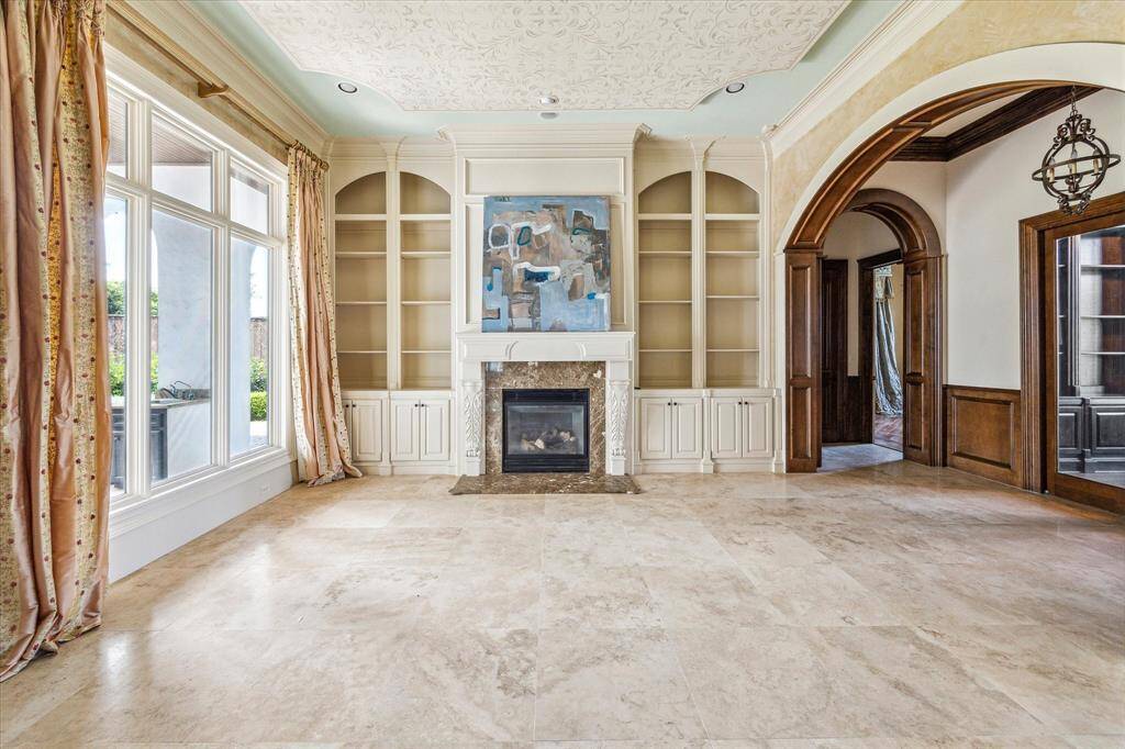 Another view of the formal sitting area with views of the backyard. The glass doors on the right lead to the study, and just passed the archway is a bedroom with en suite bathroom.
