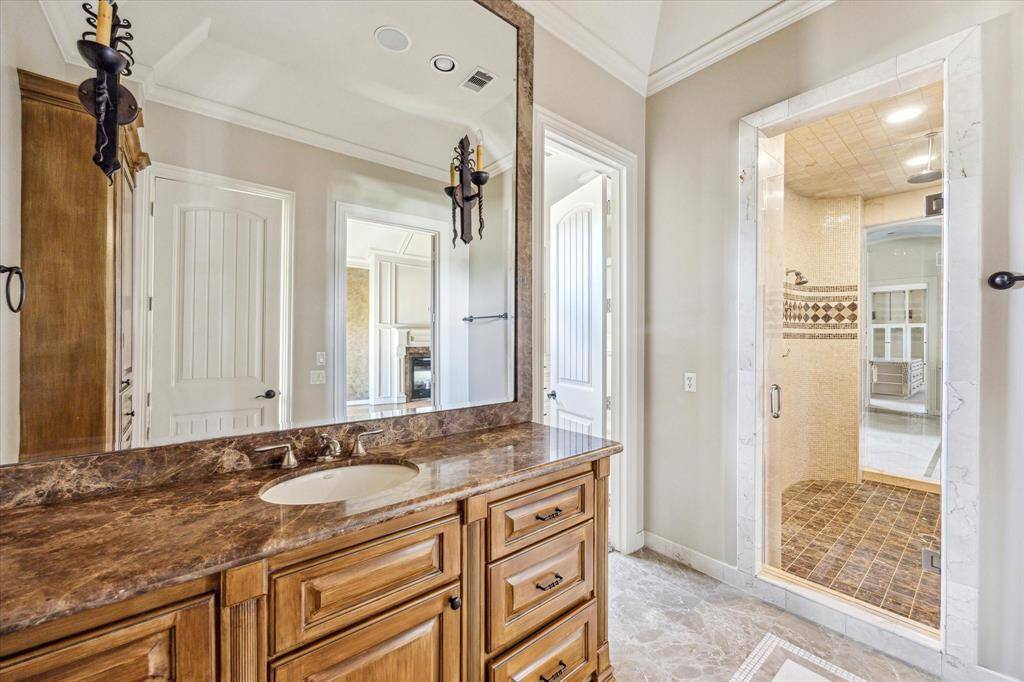 The primary bathroom includes two areas separated by a walk-through shower. Each side includes a vanity, walk-in closet and water closet.